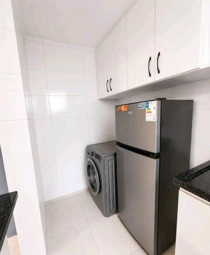 Apartamento no Jabaquara — cozinha com geladeira e máquina de lavar