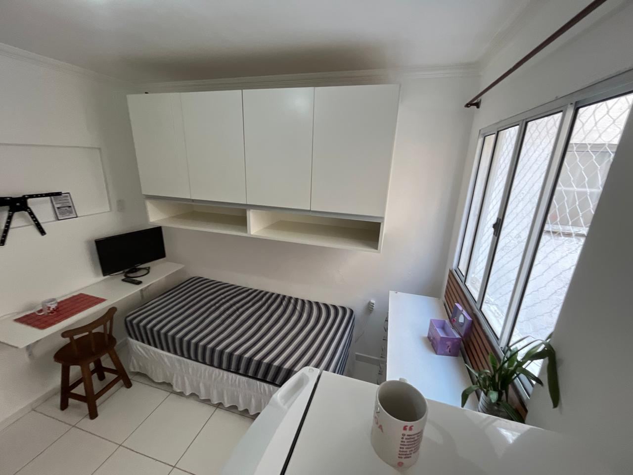 Kitnet mobiliada no bairro Saúde — quarto com cama e armários planejados